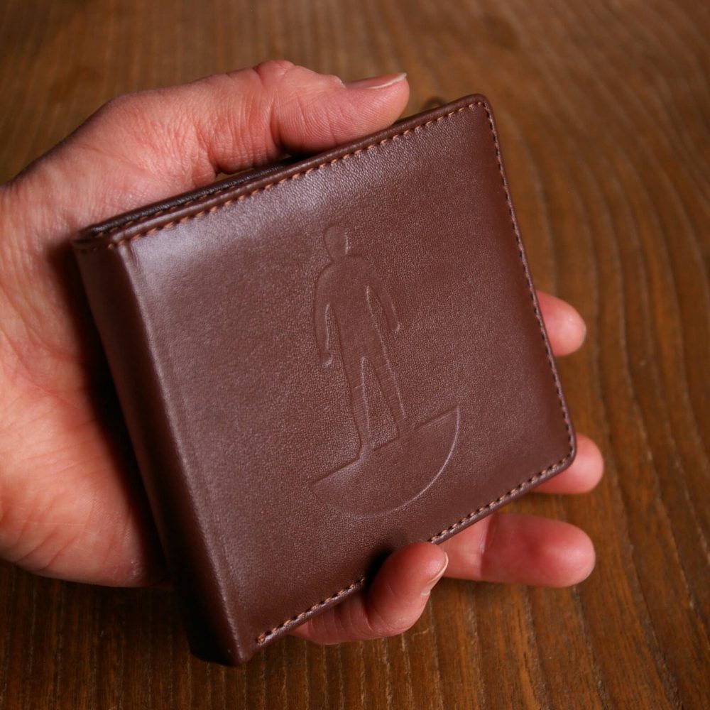 Hand holding a Subbuteo wallet with logo on the front